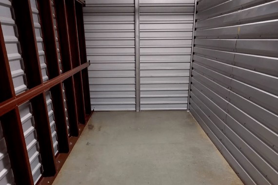 An empty, swept storage unit with a roll up door