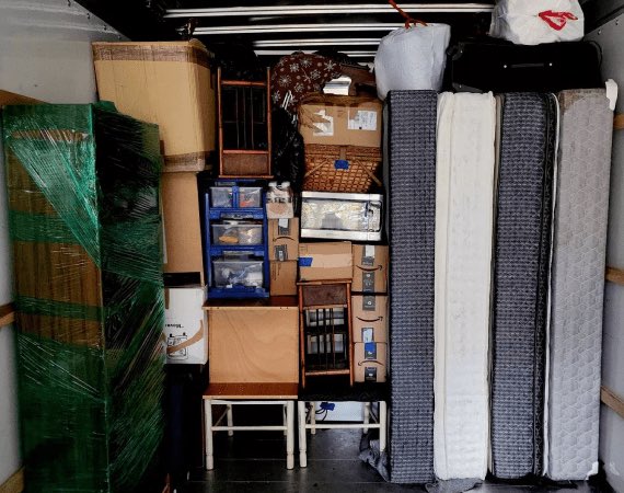 Mattresses, wrapped furniture and boxes packed floor to ceiling in a moving truck